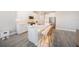 Elegant kitchen featuring white cabinets, stainless steel appliances, and a spacious center island with seating at 8719 Winning Fields Rd, New Port Richey, FL 34655