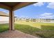 Covered patio overlooking a lush lawn and a serene lake surrounded by well-maintained homes at 8719 Winning Fields Rd, New Port Richey, FL 34655