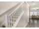 A bright staircase with white railing leads to the upper level, adjacent to an open living area at 8719 Winning Fields Rd, New Port Richey, FL 34655