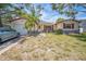 Charming single-story home with a palm tree in the front yard, featuring red window trim and a garage at 9029 109Th Ave, Seminole, FL 33777