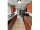 View of the kitchen with stainless steel appliances, wood cabinets, and tiled flooring at 9106 Telford Ct, Tampa, FL 33615