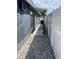 Side yard featuring pea gravel, concrete walkway, gray siding, and white fence at 9106 Telford Ct, Tampa, FL 33615