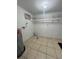 Utility room with tiled floor, water heater, shelving, and AC unit at 9106 Telford Ct, Tampa, FL 33615