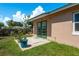 Exterior of home with a patio and backyard featuring healthy green grass and various potted plants at 920 York Dr, Brandon, FL 33510