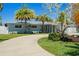 Lovely single-story home features mature landscaping, a winding driveway, and a welcoming entrance at 9485 Treasure Ne Ln, St Petersburg, FL 33702