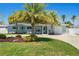 Charming single story home with mature palm trees, well manicured lawn, and updated curb appeal on a sunny day at 9485 Treasure Ne Ln, St Petersburg, FL 33702