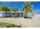 Charming single-story home with well-maintained landscaping, palm trees, and a long drive leading to a single car garage at 9485 Treasure Ne Ln, St Petersburg, FL 33702