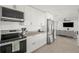 Modern kitchen with stainless steel appliances, sleek white cabinets, and seamless transition to open living area at 9485 Treasure Ne Ln, St Petersburg, FL 33702