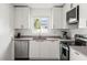 Bright kitchen featuring stainless steel appliances, sleek white cabinetry, and modern countertops at 9485 Treasure Ne Ln, St Petersburg, FL 33702