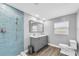 Modern bathroom featuring a gray vanity, blue tile shower, and wood look tile floor at 9591 Commodore Dr, Seminole, FL 33776
