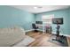 Bright bedroom with a blue accent wall, hardwood floors, and ample workspace at 9591 Commodore Dr, Seminole, FL 33776