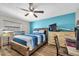 Comfortable bedroom featuring a blue accent wall, ceiling fan, and wood-look flooring at 9591 Commodore Dr, Seminole, FL 33776