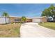 Charming single-story home featuring a spacious driveway, two-car garage, and tropical landscaping at 9591 Commodore Dr, Seminole, FL 33776