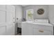 Practical laundry room featuring a washer, dryer, and utility sink with natural light at 9591 Commodore Dr, Seminole, FL 33776