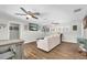 Cozy living room with wood floors, ceiling fans, and ample natural light at 9591 Commodore Dr, Seminole, FL 33776