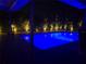 Inviting pool area illuminated at night with landscaping and ambient lighting at 9591 Commodore Dr, Seminole, FL 33776