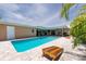 Beautiful backyard with a sparkling pool, covered patio, outdoor games, and lush landscaping at 9591 Commodore Dr, Seminole, FL 33776