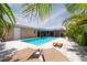 Inviting backyard with a pool, patio, lounge chairs and tropical plants at 9591 Commodore Dr, Seminole, FL 33776