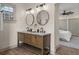 Bathroom featuring double vanity, wood-look floors, and modern lighting at 100 E Fern St, Tampa, FL 33604