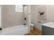 Bathroom with white tub, hexagon tile wall, and modern fixtures at 100 E Fern St, Tampa, FL 33604