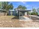 Blue house featuring a convenient carport, a well-maintained lawn, and ample yard space at 100 E Fern St, Tampa, FL 33604