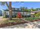 Charming home with a vibrant red door, lush landscaping, and a welcoming walkway at 100 E Fern St, Tampa, FL 33604
