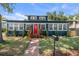 Charming single-story home featuring a red front door, brick pathway, and well-manicured landscaping at 100 E Fern St, Tampa, FL 33604