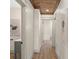 Hallway featuring wood-look floors, white walls, and modern art pieces at 100 E Fern St, Tampa, FL 33604