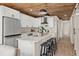 Modern kitchen featuring white cabinets, stainless steel appliances, an island and wood ceiling at 100 E Fern St, Tampa, FL 33604