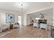 Open living space with fireplace, comfortable seating, wood floors, and updated kitchen in the background at 100 E Fern St, Tampa, FL 33604
