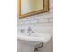 Elegant bathroom featuring a pedestal sink, subway tile backsplash, and a framed mirror at 102 S Moody Ave # 1, Tampa, FL 33609