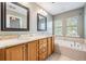 Bathroom featuring a double sink vanity with granite counters, a soaking tub, and tile flooring at 102 S Moody Ave # 1, Tampa, FL 33609