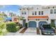 A two story home with terracotta tile roof, blue garages and truck parked in the driveway at 102 S Moody Ave # 1, Tampa, FL 33609