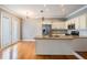 Modern kitchen featuring stainless steel appliances, granite countertops, subway tile backsplash, and hardwood floors at 102 S Moody Ave # 1, Tampa, FL 33609