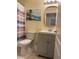 Cozy bathroom with tiled floors, gray vanity, decorative mirror, and stylish shower curtain at 1111 Jasmine Creek Ct, Sun City Center, FL 33573