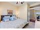 Well-lit bedroom featuring a plush bed, stylish linens, and views into the living area at 1111 Jasmine Creek Ct, Sun City Center, FL 33573