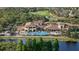 An aerial view of a large community pool overlooking a serene lake, offering a resort-style living experience at 1111 Jasmine Creek Ct, Sun City Center, FL 33573