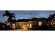 Charming single-story home featuring well-manicured landscaping and a welcoming, illuminated facade at dusk at 1111 Jasmine Creek Ct, Sun City Center, FL 33573