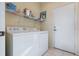 Functional laundry room with a washer and dryer, storage shelves, and easy access to the exterior at 1111 Jasmine Creek Ct, Sun City Center, FL 33573