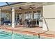 Covered patio with outdoor dining and seating next to the pool, providing an inviting space for relaxation and entertainment at 1111 Jasmine Creek Ct, Sun City Center, FL 33573