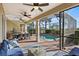 Outdoor patio featuring a screened-in pool, dining area, and comfortable seating under a covered area with ceiling fans at 1111 Jasmine Creek Ct, Sun City Center, FL 33573