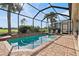 Screened pool area featuring a pool with brick border and lounge chairs, offering a relaxing outdoor space with golf course view at 1111 Jasmine Creek Ct, Sun City Center, FL 33573