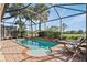 Relaxing screened-in pool area with a brick surround, seating, and lush landscaping creating a private oasis at 1111 Jasmine Creek Ct, Sun City Center, FL 33573