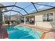 Enclosed pool area featuring clear water, brick patio, outdoor dining area, and a screen enclosure for comfortable outdoor living at 1111 Jasmine Creek Ct, Sun City Center, FL 33573