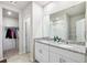 Bathroom featuring double sinks, white cabinets, granite countertops and a walk-in closet at 11123 Thornberry Dr, Spring Hill, FL 34609