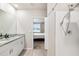 Bathroom featuring double sinks, white cabinets, granite countertops and a glass-door shower at 11123 Thornberry Dr, Spring Hill, FL 34609