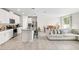 Open-concept design featuring an island kitchen, dining area, and living room with neutral tones and tile flooring at 11123 Thornberry Dr, Spring Hill, FL 34609