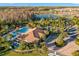 Aerial view of the community center with a large pool, cabanas, parking, and lush landscaping in a residential area at 11354 Callisia Dr, Odessa, FL 33556
