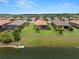 Aerial view of homes with tile roofs, manicured lawns and landscaping near a lake in a residential community at 11354 Callisia Dr, Odessa, FL 33556