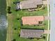 Aerial view of homes with tile roofs, manicured lawns and landscaping next to a lake in a residential community at 11354 Callisia Dr, Odessa, FL 33556